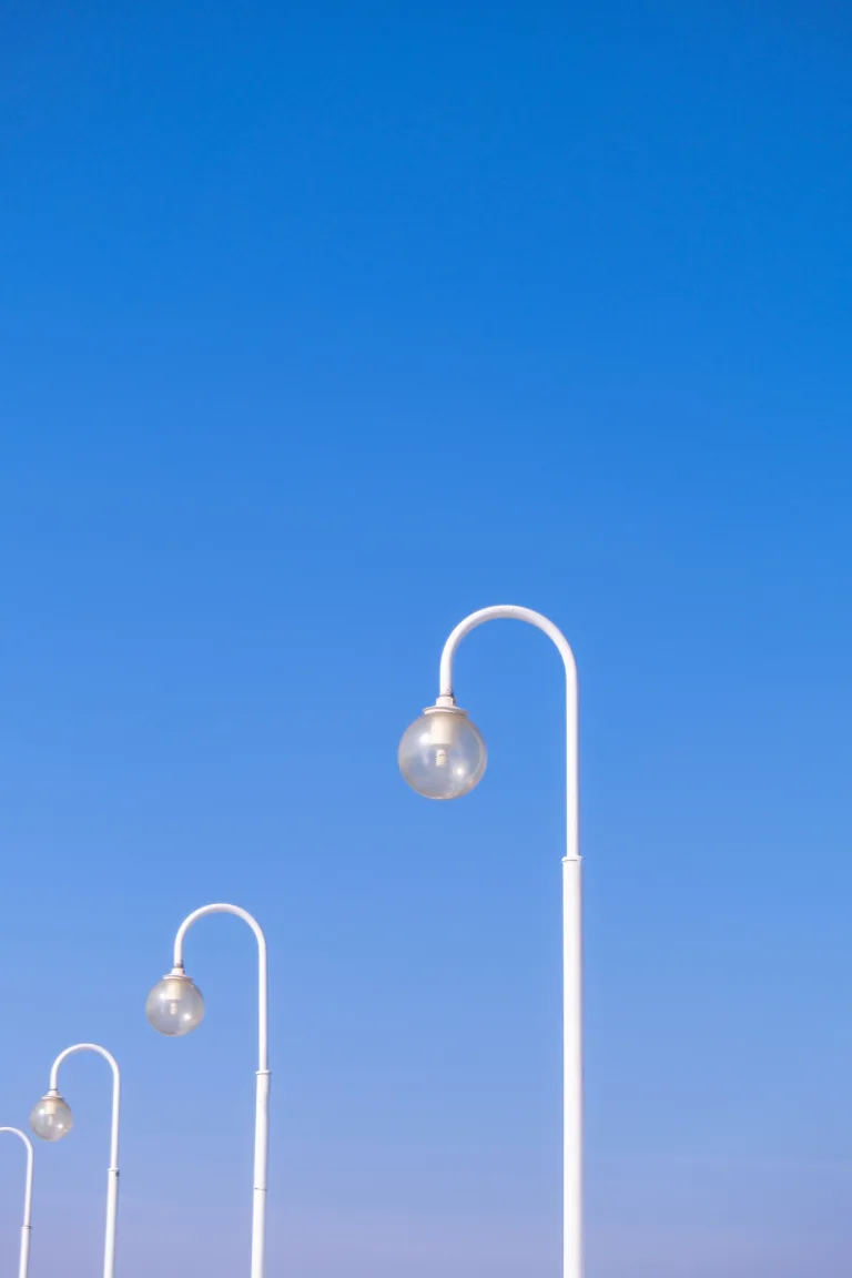 Street lights at daytime on blue sky background. Creative abstract pattern photo. Round Street lamps
